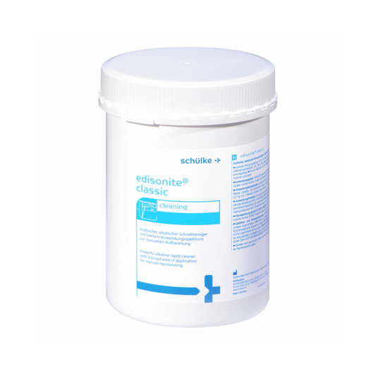 Ein weißer 1kg-Behälter der Schülke & Mayr GmbH mit der Aufschrift "Auslaufartikel: Schülke Instrumentenreinigung edisonite classic" mit blauer Schrift und Grafik, mit Schraubverschluss; ideal als manueller Pulverreiniger für Laborgeräte, Angaben in mehreren Sprachen auf dem Etikett.