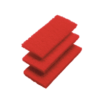 Three red Haug scouring pads, medium red, from Haug Bürsten KG, made of synthetic nonwoven fabric, are stacked on a white background—perfect for professional cleaning.