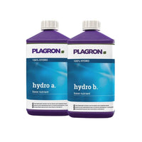 Su uno sfondo bianco sono raffigurate due bottiglie di plastica di Plagron Hydro A + B della Bertels B.V., fertilizzante bicomponente per la fase di fioritura, destinato a substrati inerti, con tappi viola ed etichette blu e bianche.
