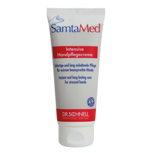 Die weiße Tube der Dr. Schnell SAMTAMED Hautpflege von DR.SCHNELL GmbH & Co. KGaA ist mit blauer und roter Schrift, einem Flip-Top-Verschluss, dem Dr.-Schnell-Logo am unteren Rand und der Hervorhebung der feuchtigkeitsspendenden Wirkung in deutscher und englischer Sprache versehen.