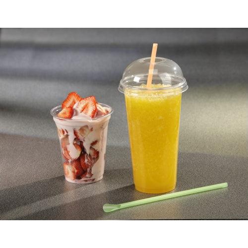 Ein mit Erdbeeren und Joghurt gefüllter Starpak 50 Trinkbecher "Hurricane" PET-Glasklar steht neben einem hohen To-Go-Becher mit orangefarbenem Slush, der mit einem Kuppeldeckel und Strohhalm versehen ist. Auf der grauen Arbeitsplatte daneben liegt ein grüner Rührstab.