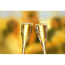 Zwei Starpak 50 Stiel-Gläser (Oberteile) für Sekt, PS 0,1 l glasklar werden zum Toast erhoben, wobei ihr klares Design lebendige Blasen vor einem sanft verschwommenen, warm beleuchteten Hintergrund hervorhebt.