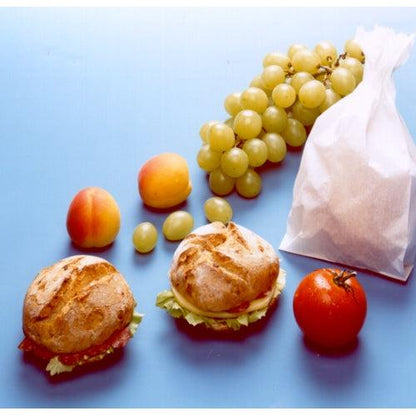 Two filled rolls in a greaseproof sandwich bag from PAPSTAR GmbH (21x10x3 cm, white, 100 pieces), as well as a tomato, two apricots, three loose grapes, and one grape are arranged on a light blue surface.