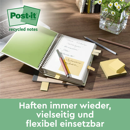 Ein aufgeschlagenes Notizbuch, auf dessen Seiten 3M Post-it® Recycling Notes, Gelb (76x127mm, 100 Blatt/Block, 6 Blöcke/Packung, 100% PEFC) befestigt sind. Oben liegt ein Stift, im Hintergrund sind eine Pflanze und ein Stifthalter zu sehen. Darunter steht ein deutscher Text.