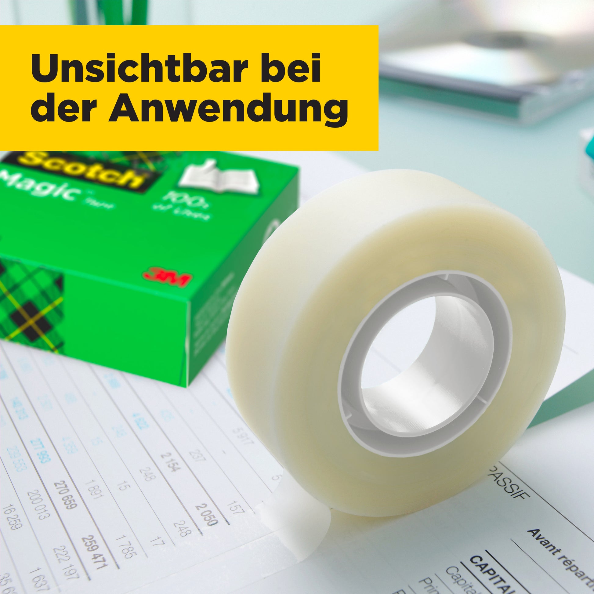 Eine Rolle Scotch® Magic™ Unsichtbares Klebeband von 3M Deutschland GmbH liegt auf einem Dokument, im Hintergrund eine grüne Packung mit gelbem Aufkleber "Unsichtbar bei der Anwendung". Vorteilspack: 24 Rollen à 19 mm x 33 m.