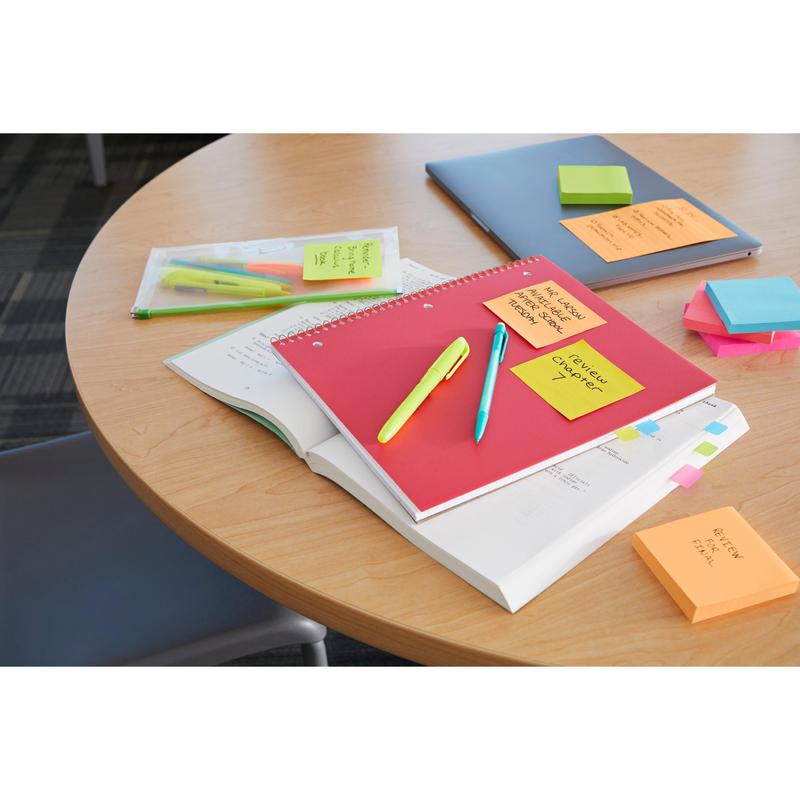 On a round table lie notebooks, pens, highlighters, a pencil case, a closed laptop, and stacks of Post-it® Super Sticky Notes (76 mm x 127 mm, 90 sheets/block, 100% PEFC) from 3M Deutschland GmbH; some notes have handwritten reminders.