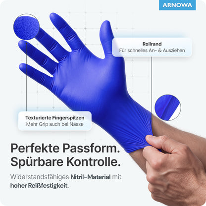 Eine Hand zieht einen ARNOMED NITRIL OCEAN BLUE Einmalhandschuh von ARNOWA GmbH an, mit Etiketten für texturierte Fingerspitzen, Rollrand, hohe Reißfestigkeit und latexfreies Material. Deutscher Text beschreibt Passform und weitere Eigenschaften.