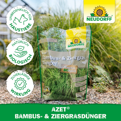 Azet Bambus- & ZiergrasDünger aus dem Neudorff Shop steht im Freien auf Stein, ideal für pflegeleichte Gräser und Gärten. Die Verpackung ist mit Zertifizierungssymbolen und dem Neudorff-Logo versehen.