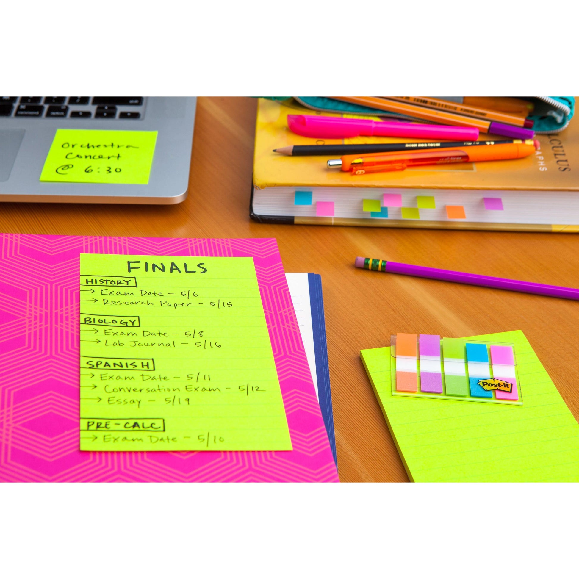 Auf einem Schreibtisch liegt ein pinkfarbener Post-it® Super Sticky Note (3M Deutschland GmbH) mit der Aufschrift "FINALS", auf dem die Prüfungstermine und -aufgaben für Geschichte, Biologie, Spanisch und Vorkalkulation aufgeführt sind. Bücher, Stifte, Bleistifte und Haftnotizen liegen verstreut auf der Oberfläche.