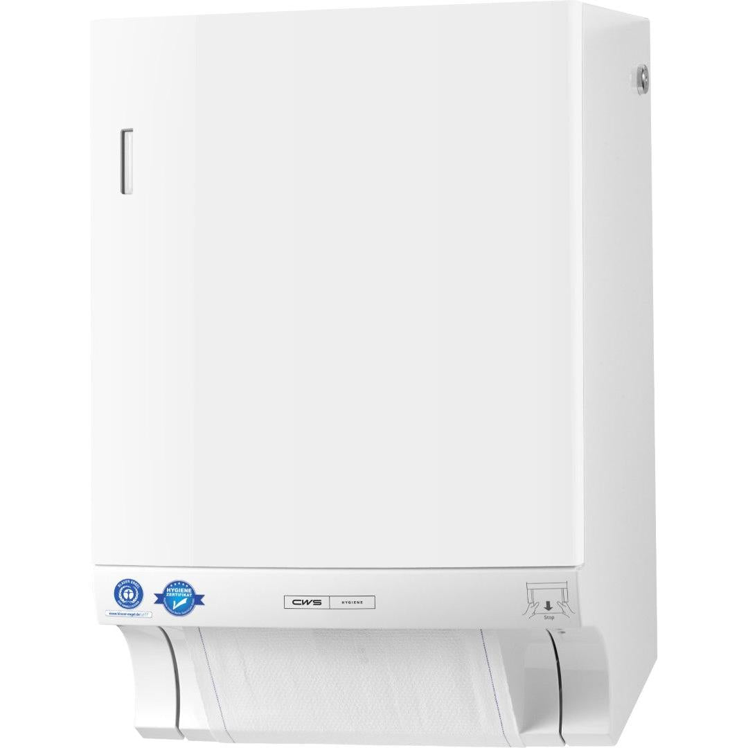 Un dispenser di asciugamani in tessuto CWS ParadiseLine Dry Slim bianco con pannello dal design sottile è fissato alla parete e mostra un foglio parzialmente estratto sul fondo. Adesivi blu, una piccola etichetta argentata e un'istruzione illustrata si trovano vicino al fondo.