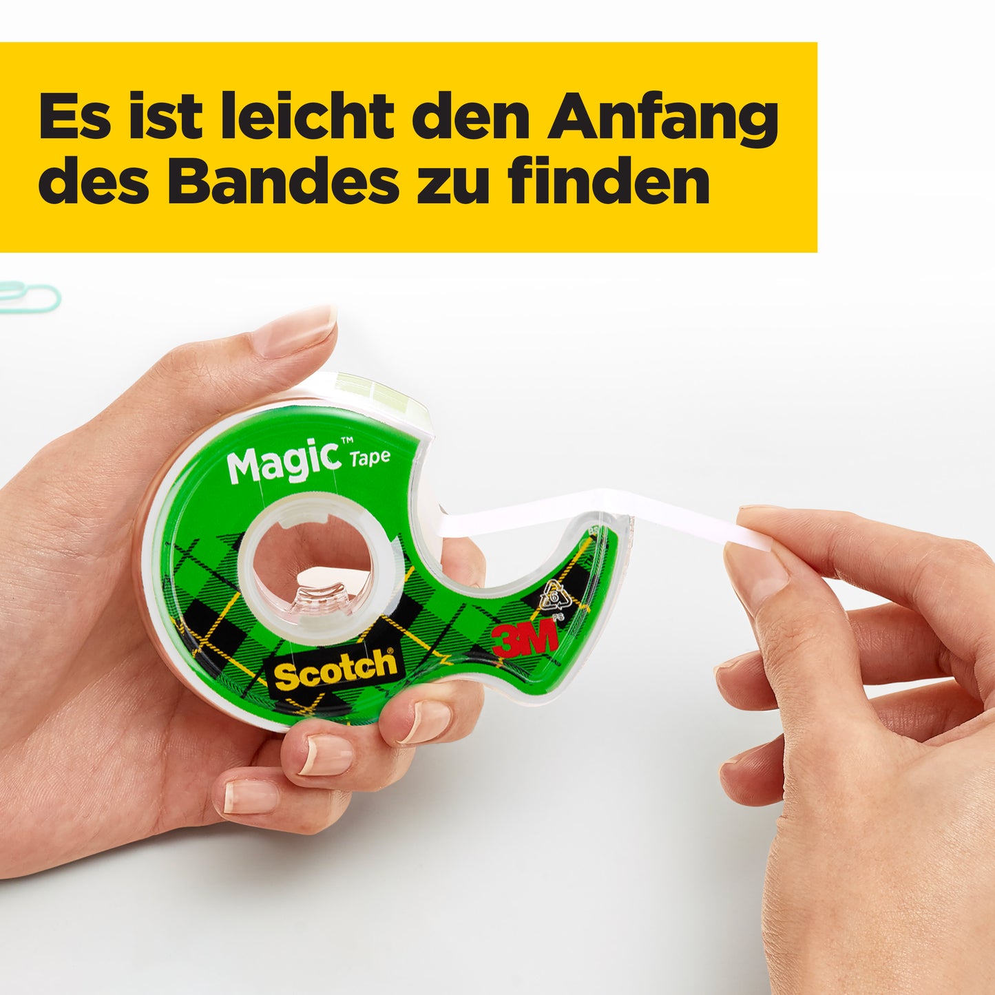 Eine Person benutzt einen grünen Handabroller mit Scotch® Magic™ Unsichtbares Klebeband (19 mm x 25 m, 1 Rolle + 5 m GRATIS) von 3M Deutschland GmbH. Auf einem gelben Kasten steht: "Es ist leicht den Anfang des Bandes zu finden.