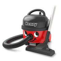 The Henry Compact Vacuum Cleaner HVR160-11 from Numatic International GmbH is a red-and-black canister vacuum with the name "Henry" on the top, a smiling face, a flexible hose, and a silver-and-black floor nozzle.