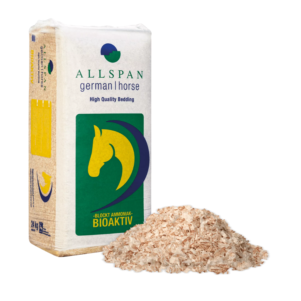 Eine Packung Allspan German Horse Classic Holzspäne Einstreu Bioaktiv, bekannt für seine hochwertige Einstreu, die sich ideal für die Stallhygiene eignet, wird neben einem kleinen Stapel des Produkts selbst präsentiert. Auf der Verpackung sind auffällig ein grün-gelbes Pferdelogo und ein Text zu sehen, der die ammoniakblockierenden bioaktiven Eigenschaften des Produkts hervorhebt.