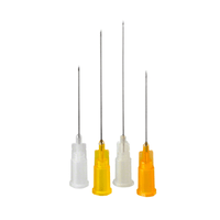 Four injection needles with colored bases are standing upright. The bases resemble those of the B. Braun Sterican® line of dental anesthesia products and are white, yellow, and orange. These disposable needles are intended for dental anesthesia applications by B. Braun Deutschland GmbH & Co. KG, and vary in length from the shortest to the longest.