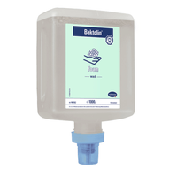 Eine an der Wand befestigte Spenderflasche mit Hartmann Baktolin® Foam Handreinigungsschaum der Paul Hartmann AG mit einer blauen Spenderdüse, die mit einer Füllmenge von 1000 ml Handwaschseife beschriftet ist. Das Flaschendesign enthält Produktinformationen und