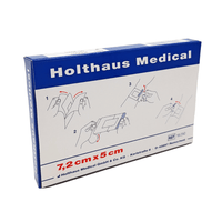 Una confezione blu e bianca denominata «Holthaus Ypsiderm® plus cerotto 7,2 x 5 cm - 5 cerotti» della Holthaus Medical GmbH & Co. KG contiene cinque cerotti. Sulla confezione sono riportate istruzioni illustrate passo dopo passo per l’uso della medicazione autoadesiva, nonché le informazioni sul produttore e il numero di riferimento 1250.