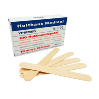The image shows a box labeled “Holthaus Ypsimed Wooden Tongue Spatulas, 18 x 150 mm – 100 pieces | Package (1 piece)” by Holthaus Medical GmbH & Co. KG, ideal for medical use. Several wooden tongue depressors are laid out in front of the box. The white box with blue and red lettering indicates the dimensions of 18 mm x 150 mm.