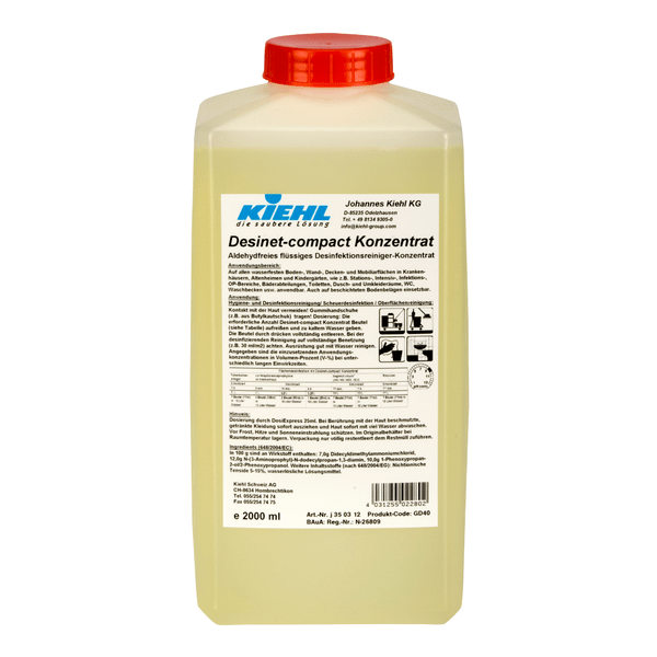 Un contenitore rettangolare di plastica da 2 litri con tappo rosso e etichetta bianca mostra il marchio Johannes Kiehl KG e le informazioni sul prodotto per Kiehl Desinet-compact Konzentrat, un concentrato liquido disinfettante senza aldeidi in lingua tedesca.