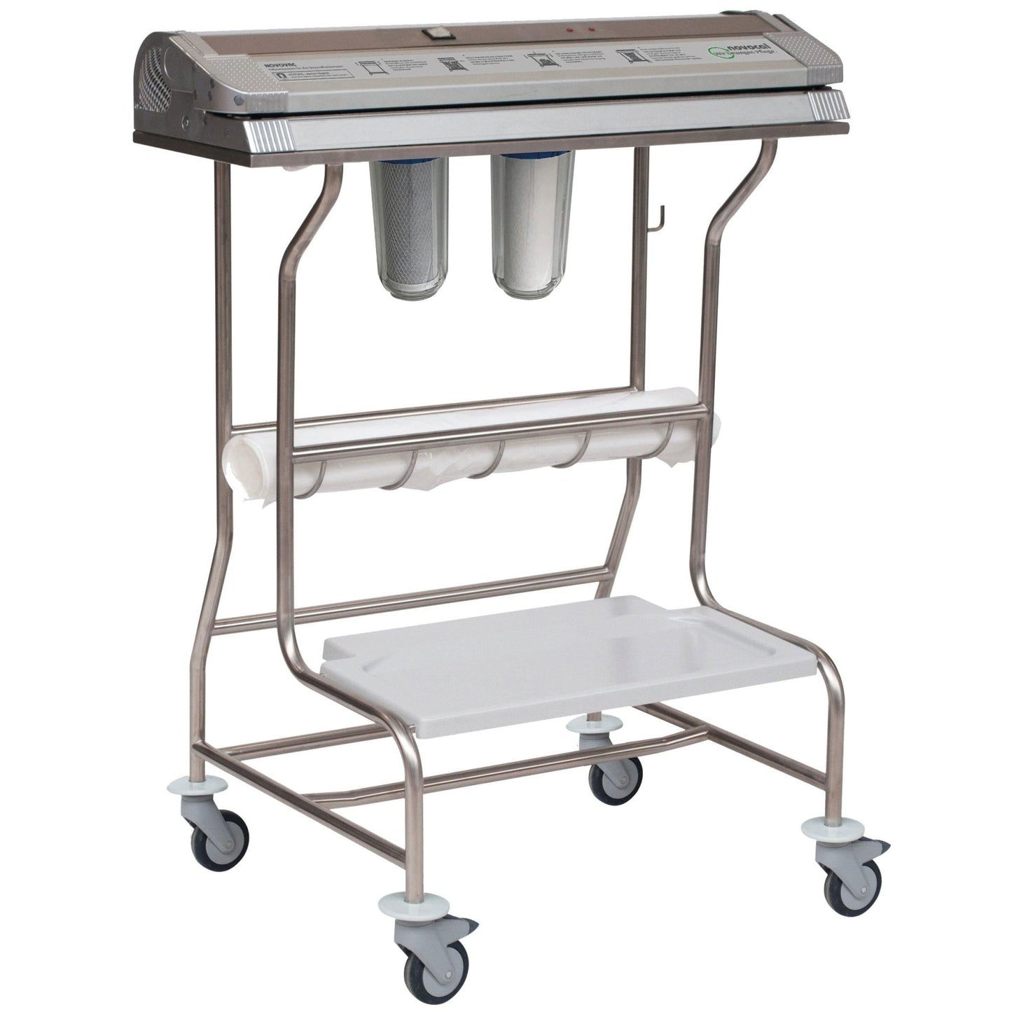 The Novocal vacuum device Novovac features a housing made of stainless steel/aluminum, a control panel on the top, two filter canisters on the bottom, a roll holder, a lower white shelf, wheels for mobility, and a triple seal up to 720 mm.
