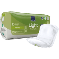 Un emballage vert et blanc d'ABENA Light Normal 2, Premium | (12 pièces) de la société Abena Re-Seller GmbH est posé à côté d'une protection non dépliée. L'emballage présente les caractéristiques du produit, des symboles et met en avant son pouvoir absorbant.