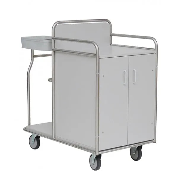 Der Novocal Stationswagen verfügt über einen robusten, vollverschweißten Edelstahlrahmen, vier Räder, einen weißen zweitürigen Schrank, eine flache Platte mit Seitenablage und ein stabiles Metallgeländer - ideal für den medizinischen Einsatz.