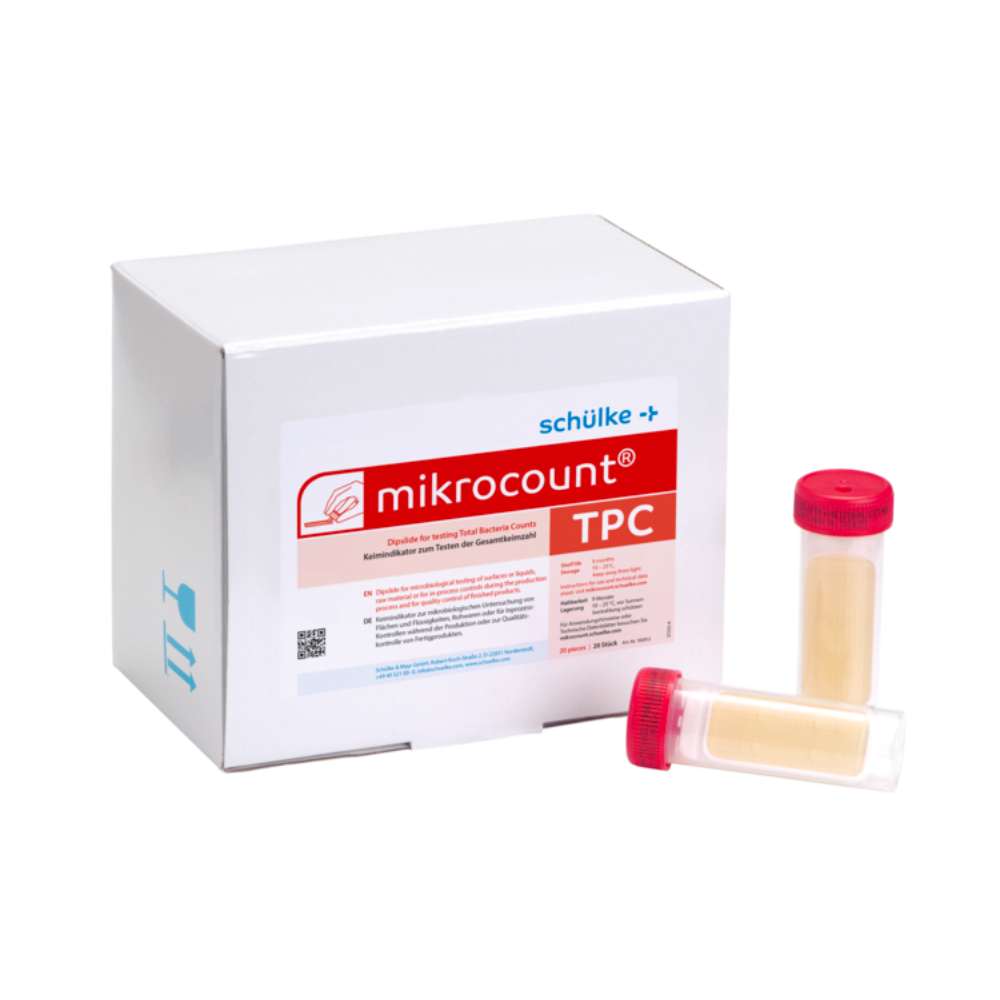 Una scatola bianca con la scritta "Schülke & Mayr GmbH Mikrocount® TPC, terriccio | Confezione (20 pezzi)" con un logo e una descrizione del prodotto accanto a due flaconcini per test microbici, uno con tappo giallo, l'altro con tappo trasparente.