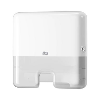 Un Tork Xpress® 552100 Mini Distributeur pour serviettes pliées en H2 Elevation, fabriqué par TORK – Essity Professional Hygiene Germany GmbH, est monté au mur. Il présente un design rectangulaire simple avec des bords arrondis, une serrure visible sur le côté droit et une ouverture en bas pour la distribution feuille à feuille de serviettes pliées.