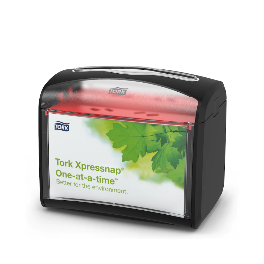 Der Tork Xpressnap® 272611 Tischspender für Servietten von TORK – Essity Professional Hygiene Germany GmbH hat eine schwarze Oberseite und eine transparente Vorderseite mit einem grünen Blattdesign und der Aufschrift „Tork Xpressnap One-at-a-time – besser für die Umwelt“. Dieser Spender verbessert die Hygiene und reduziert gleichzeitig effizient den Serviettenverbrauch.