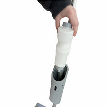 Eine Person setzt eine weiße Reinigungslösungsflasche in den Griff des Arcora Ultra Mobile Spray Mop Systems der Arcora International GmbH auf weißem Hintergrund ein.