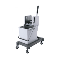 Il sistema a secchio singolo con strizzatore verticale di Vileda GmbH comprende un secchio grigio dotato di strizzatore verticale, montato su un carrello portasecchio. Il carrello è dotato di quattro rotelle e di una maniglia nera che ne facilitano la manovrabilità e rispecchia il design CombiSpeed di Vileda Professional.