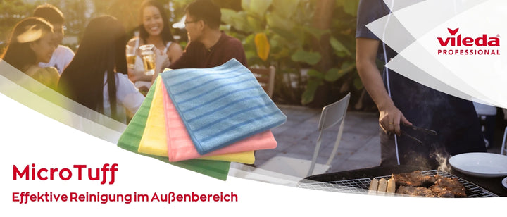 Werbebild für Vileda Professional: Im Vordergrund sind vier bunte Mikrofasertücher der Serie 'MicroTuff' (grün, gelb, pink und blau) zu sehen. Im Hintergrund grillt eine Person Fleisch auf einem Grill, während eine Gruppe junger Menschen bei Getränken und guter Stimmung draußen zusammensitzt. Text: 'MicroTuff – Effektive Reinigung im Außenbereich'.