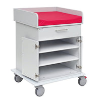 A white Novocal changing table on a rolling cart base with a durable solid plastic top, a red padded work surface, a pull-out drawer, two open doors, and three shelves for storage and portability.
