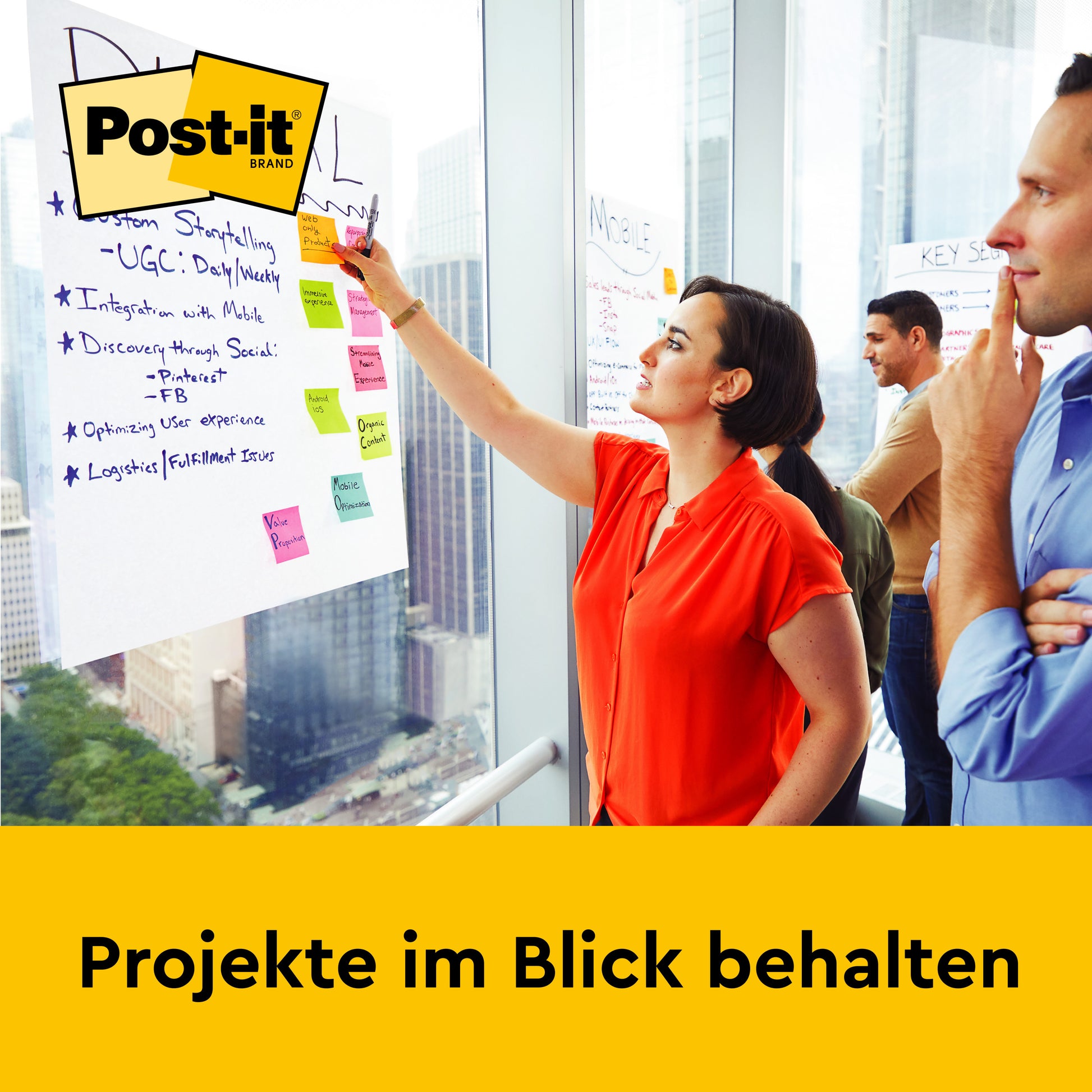 Eine Frau schreibt auf ein Post-it® Super Sticky selbsthaftendes Meeting Chart/Flipchart (63,5x76,2 cm) von 3M Deutschland GmbH, während drei Kollegen zusehen. "Projekte im Blick behalten." Das Post-it Markenlogo erscheint in der oberen linken Ecke.
