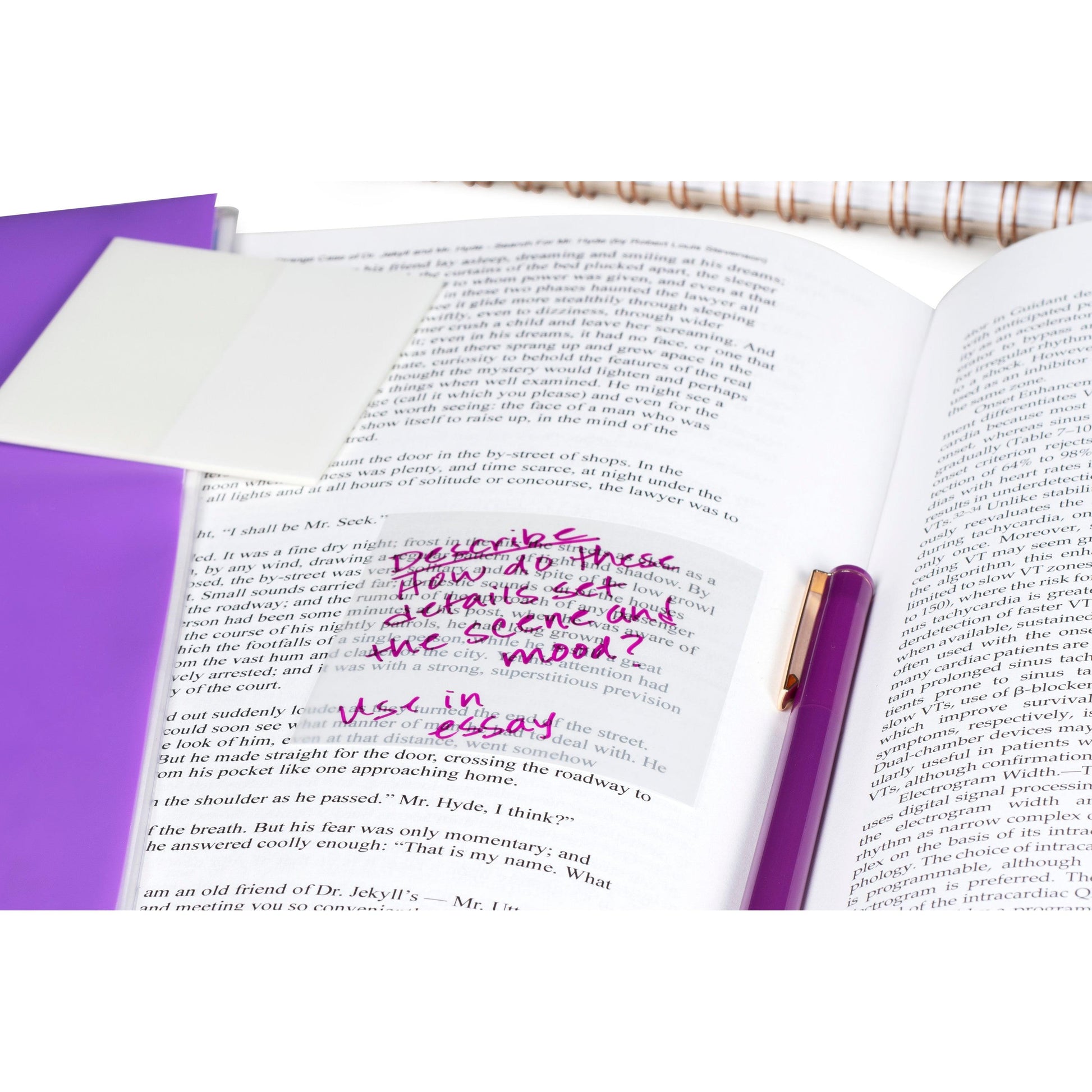 Ein aufgeschlagenes Buch mit einer handschriftlichen Notiz in rosa Tinte auf einer Post-it® Transparent Note (73 mm x 73 mm, 36 Blatt/Block, 3M Deutschland GmbH) neben einem Stift, einem lila Ordner und einem Spiralheft.