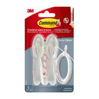 Eine Packung Command™ Kabelhalter, 17304-FR von 3M Deutschland GmbH, enthält zwei weiße Kabelhalter, Klebestreifen und ein weißes Kabel in einer durchsichtigen Kunststoffverpackung - perfekt, um das Kabelchaos zu minimieren und die Kabelorganisation zu verbessern.