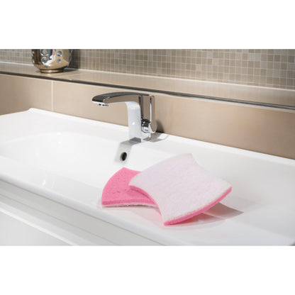 Ein weißes Waschbecken mit einem verchromten Wasserhahn zeigt den Scotch-Brite® Bath XXL Reinigungsschwamm von 3M Deutschland GmbH, rosa auf der einen und weiß auf der anderen Seite, ideal für Kalkablagerungen entfernen. Im Hintergrund erscheinen beige und hellbraune Fliesen.