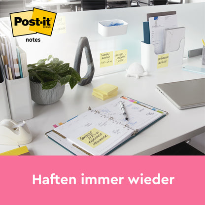 Ein aufgeräumter Bürotisch zeigt Post-it® Notes, Gelb, 38 mm × 51 mm (100 Blatt/Block, 12 Blöcke/Packung, 100% PEFC) von 3M Deutschland GmbH. Die Notizen sind auf dem Schreibtisch und der Trennwand sichtbar. Der Text darunter lautet: "Haften immer wieder.