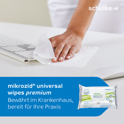 A person uses Schülke Mikrozid® universal wipes premium disinfection wipes to clean a white keyboard. The text reads: "Schülke Mikrozid® universal wipes premium disinfection wipes. Proven in hospitals, ready for your practice." At the bottom of the image, the product packaging is shown, highlighting its effectiveness for quick disinfection of medical surfaces.